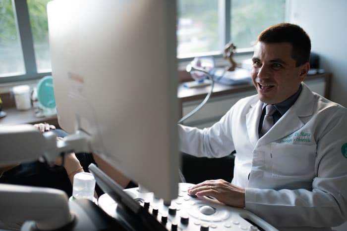 Dr. Diego Dimarco conversando com paciente durante consulta no consultório.